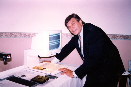 Rob Knowles views computer screen with magnifier displayed at clinic