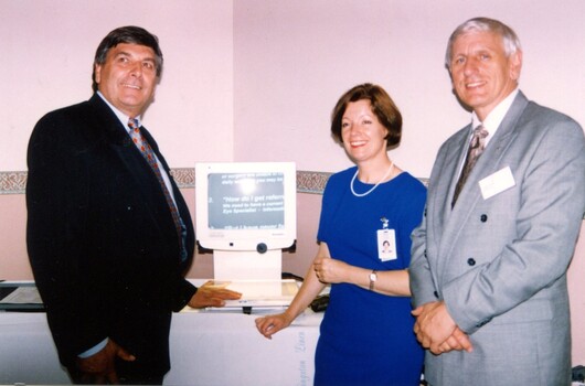 Rob Knowles, unknown woman and John Cook with magnified screen