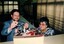 Man and woman stand next to a box full of spectacles