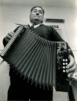 Man standing and playing an accordion