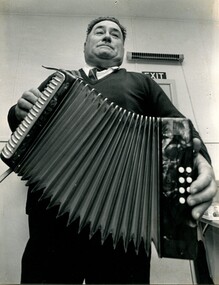 Man standing and playing an accordion