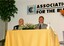 Max Walker sits at a table on the stage with possibly his father Max Walker
