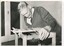 Man weaves cord over stool base