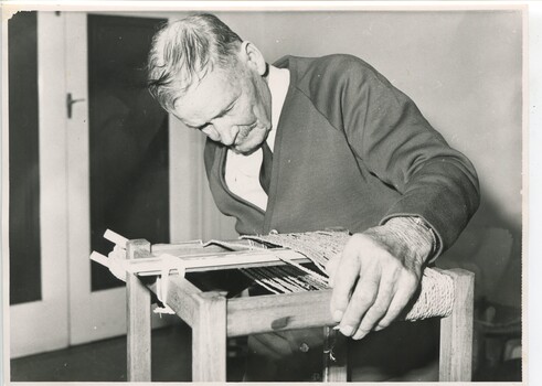 Man weaves cord over stool base