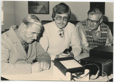 Terry Fraser with two men operating a CB radio