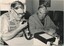 Two men operate a CB radio