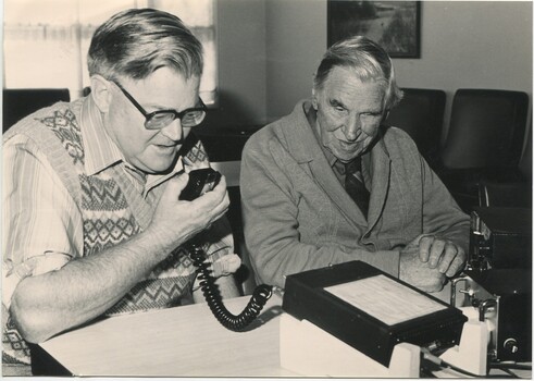 Two men operate a CB radio