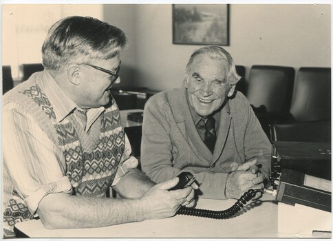 Two men operate a CB radio