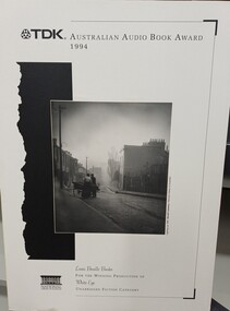 Photograph of two people standing by cart at the top of a city road