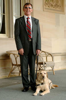 Kevin Murfitt with his dog guide at Government House