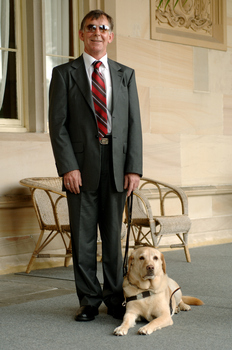 Kevin Murfitt with his dog guide at Government House