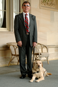 Kevin Murfitt with his dog guide at Government House