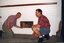 Ian Mills and Noel Read place the suitcases into the fireplace