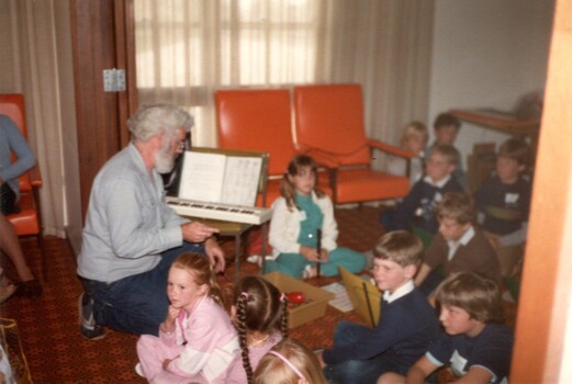 Primary school children playing musical instruments in nursing home