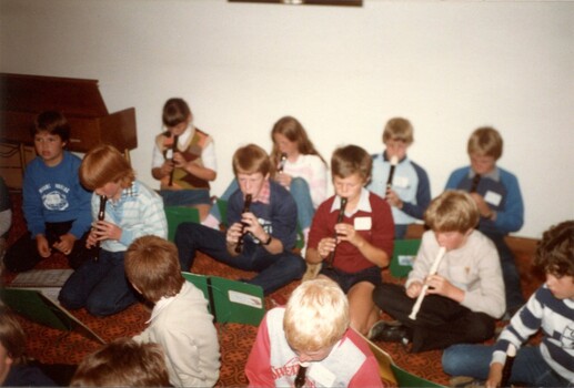 Primary school children playing musical instruments in nursing home