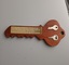 Wooden key with plaque and two metal keys attached