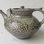 A lidded teapot with mottled salt glazing