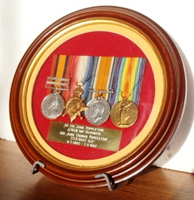 Small round frame with four medals displayed
