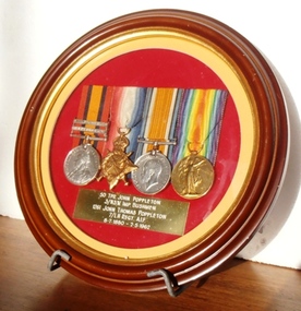 Small round frame with four medals displayed
