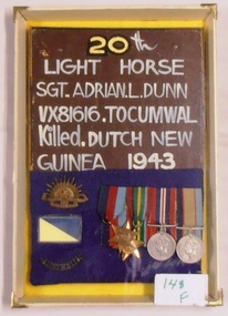 A board with medals, badge and writing