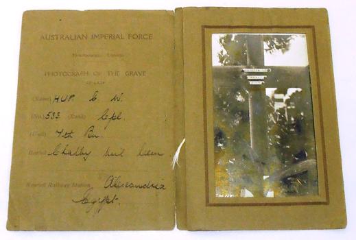 Brown paper folder with photograph of soldier's grave inside.