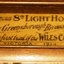 Brass plate attached to frame of photograph.