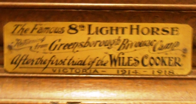 Brass plate attached to frame of photograph.