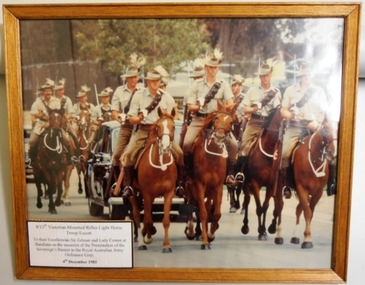 Soldiers on horseback surrounding a car.