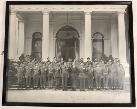 Large group of soldiers on steps of grand building.