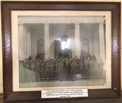 Soldiers lined up on steps of grand building.