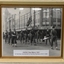 Servicemen marching with flag in city street