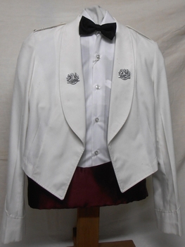 A short jacket with badges on lapels worn with a bow tie.