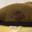 Khaki beret with badge and coloured patch on side.