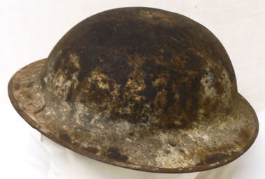 A steel hat worn for protection by a soldier.