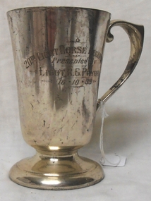 Silver tankard with engraving on side.