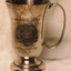 Silver mug with handle and inscription on both sides.