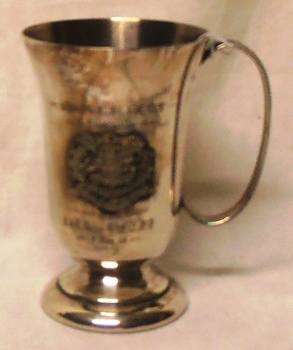 Silver mug with handle and inscription on both sides.