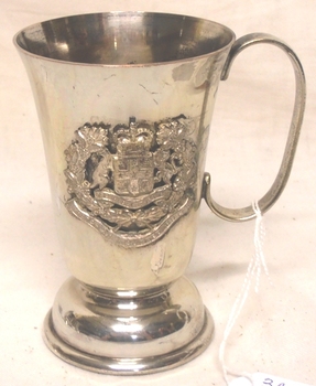 Metal drinking cup with badge on side