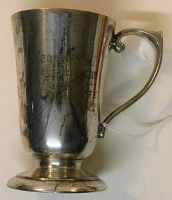 Silver cup with handle and inscription on side.