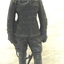 Small sculpture of soldier on wooden base.