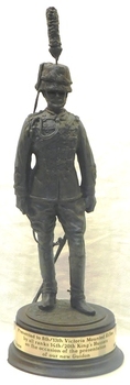 Small sculpture of soldier on wooden base.