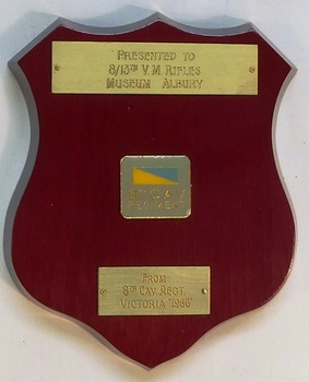 Small wooden shield with coloured badge and colour patch