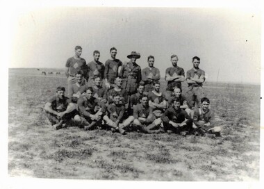 Football team in three rows, army officer at centre.