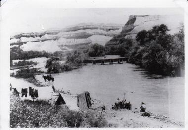 Tent, soldiers near lake; washing drying on line.