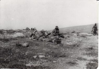 Soldier with rifle on rocky hill