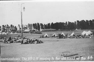 Soldiers in open paddock near tents