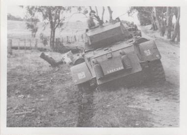 Armoured car bogged in a drain beside a road 