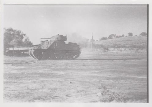 Large army tank on dusty hillside