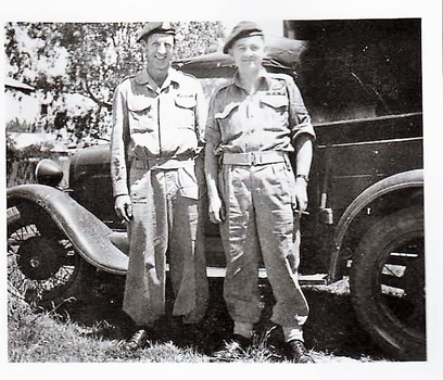 Two soldiers stand in front of old utility