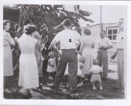 Group of men and women with little children.